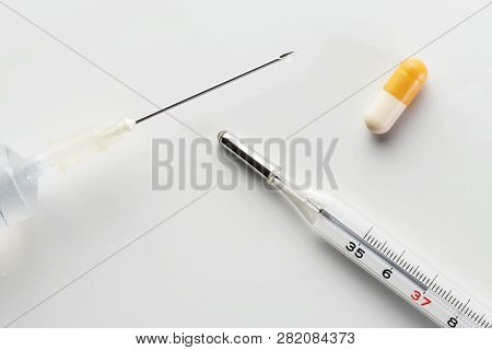 Medical Syringe, Mercury Thermometer And Pill Capsule Isolated On White Background. Vaccination, Inf