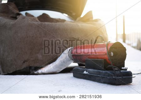Emergency Car Engine Warming In Winter With A Heater. Flooded Spark Plugs Of Car And Failure To Star
