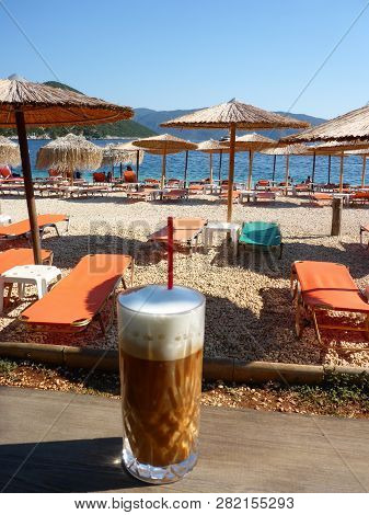 Summer Morning With Freddo Cappuccino Greek Cold Coffee Drink On The Backgraund Straw Umbrellas And 