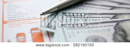 The Silver Pen With Dollar Banknotes Is On The International Euro-protocol Form For Filling And Inde