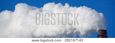 White Smoke Comes From Pipes Against Blue Sky. Problem Harmful Emissions And Air Pollution Of Centra