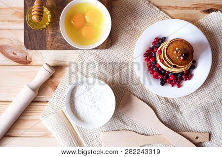 The Process Of Cooking Pancakes. Pancakes With Berries On A White Plate. Accessories And Ingredients