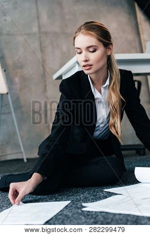 Businesswoman In Black Suit Sitting On Floor And Taking Document