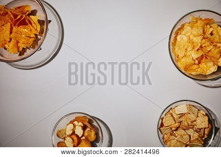 Top View Of Delecious Snacks In Bowls On White Background