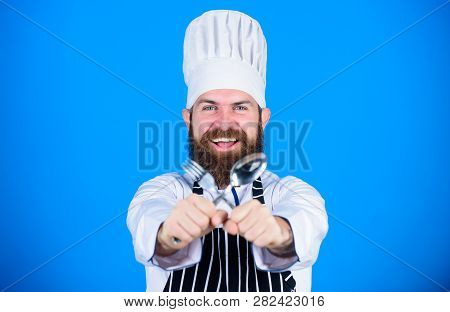 Man Handsome With Beard Holds Kitchenware On Blue Background. Cooking Process Concept. Lets Try Dish