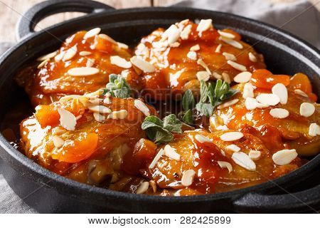 Tender Sticky Chicken Thighs With Apricot Glaze And Almond Flakes Close-up In A Pan. Horizontal