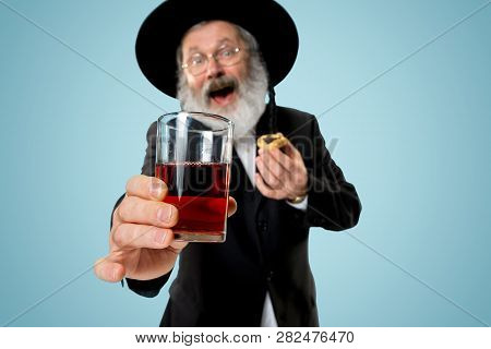 The Senior Orthodox Jewish Man With Black Hat With Hamantaschen Cookies For Jewish Festival Of Purim