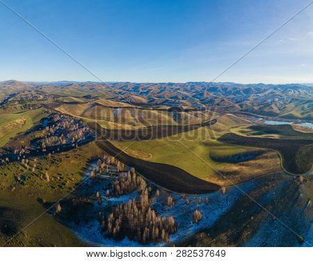 Drone view of autumn meadow hiils and forest. Aerial nature shot. Altai regoin, Russia  