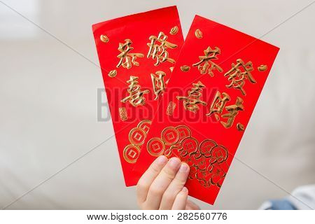 Kid Holding Pair Of Red Pockets Written Kung Hei Fat Choy Translation-wshing You Prosperity