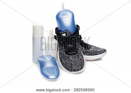 Sports shoes care. Electric shoes dryer with UV sterilization on a white background,  Deodorant for shoe and antifungal agent. Shoe care products. Concept of healthy feet. Fitness and sport footwear