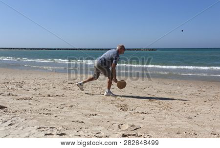 Handsome Mature Man Playing Tennis On The Beach