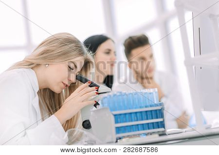 Close Up.a Modern Female Scientist Looks Into A Microscope In A Laboratory