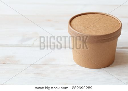 Kraft paper soup bowl with lid on a white table