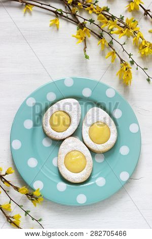 Homemade Easter Lemon Cookies And Forsythia Blooming Twigs On A Light Background.