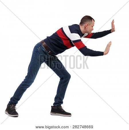 back view of man pushes wall. Isolated over white background. Rear view people collection. backside view of person. The guy in the sweater pushes something in front of him.