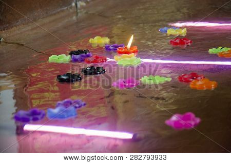 Ritual Praying Colorful Candle Floating On Water For Pray Reclining Buddha Image At Wat Phra Non Cha