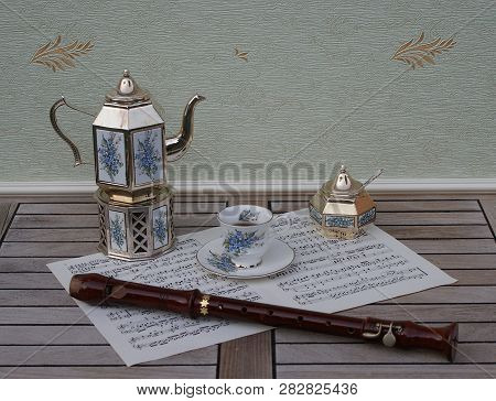 English Teacup And Saucer, Silver-plated Teapot On A Silver Stove, Sugar Bowl And Sugar Spoon With F