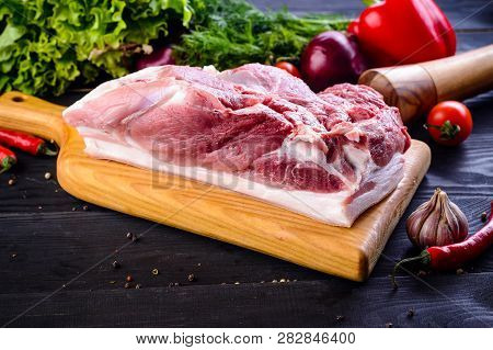 Raw Pork Meat. Fresh Steaks Tenderloin On Wooden Cutting Board On Dark Background. Raw Pork Shoulder