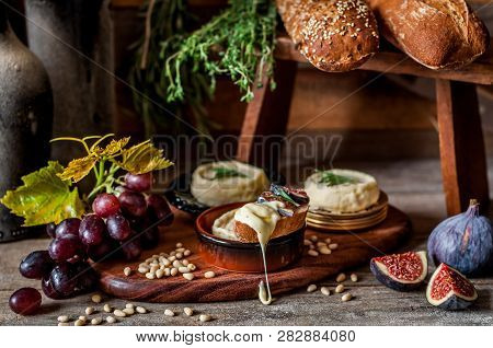 Soft Spreadable French Stinky Cheese On A Slice Of Bread With Fruit And Pine Nuts