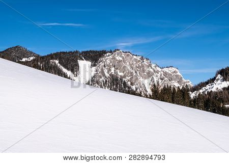 Snow Covered Slope In Holiday-resort Hohentauern With Mountain Sunkmauer On A Sunny Day In Winter In