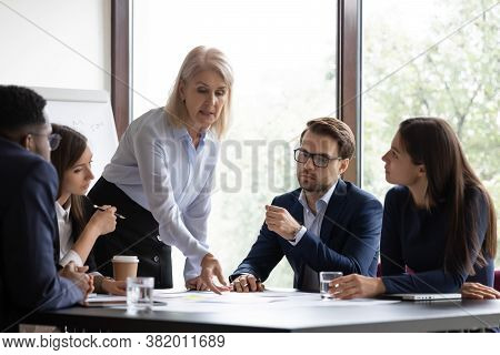 Mature Business Lady Pointing Colleagues To Important Place In Documents