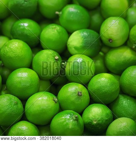 Many Fruits Of Green Ripe Refreshing Limes Are Lying In The Grocery Store. A Rich Harvest Of Fruit. 