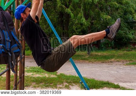 Athlete Doing Pull-up On Horizontal Bar. Male Sportsman Doing Fitness Exercises On Playground Outdoo