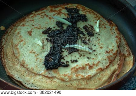 Black Caviar On A Pancake With Slices Of Butter