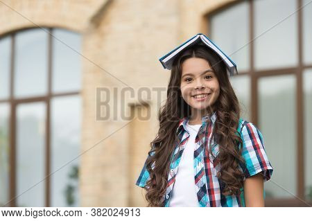 House Of Knowledge. Happy Child Hold Book On Head. School Library. Library Reader Outdoors. Lending 
