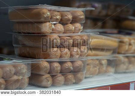 Raw Sausages In Packages On Shelves In A Retail Store. Packets Of Meat At The Supermarket