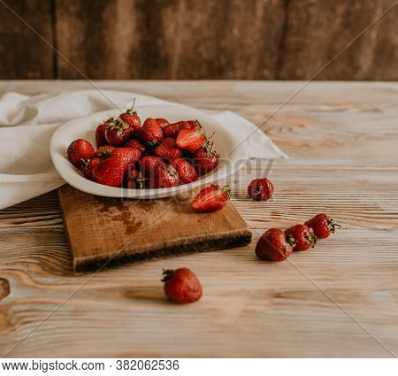 Juicy Red Strawberry Lies On The Wooden Board