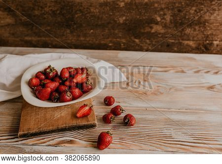 Juicy Red Strawberry Lies On The Wooden Board