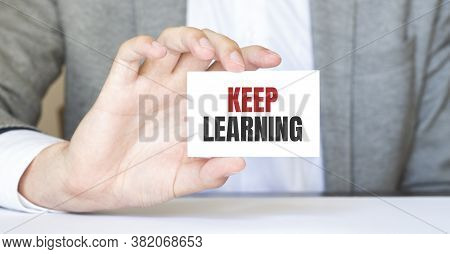 Businessman Holding A Card With Text Keep Learning