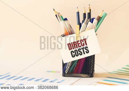 Card With Text Direct Costs On The Pen Box In The Office. Diagram And White Background
