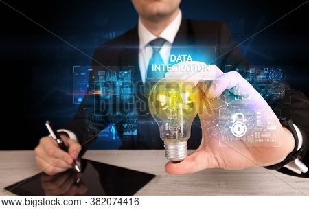 Businessman holding lightbulb with DATA INTEGRATION inscription, online security idea concept