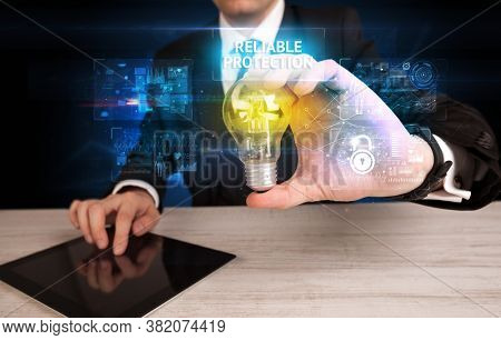 Businessman holding lightbulb with RELIABLE PROTECTION inscription, online security idea concept