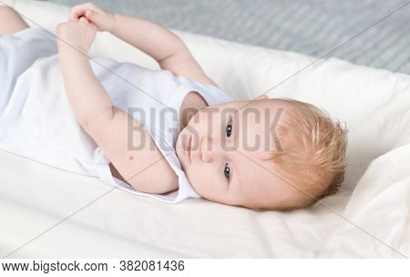 A Beautiful Newborn With Traces Of Bcg Vaccination-the Tb Vaccine-on His Arm. The Baby Is Lying On T