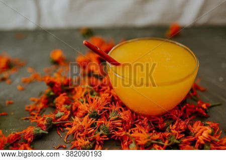 A Small Cup Is Filled To The Top With Yellow Liquid Honey, Orange Calendula.
