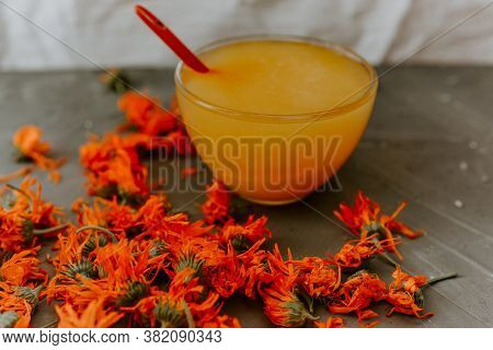 A Small Cup Is Filled To The Top With Yellow Liquid Honey, Orange Calendula.