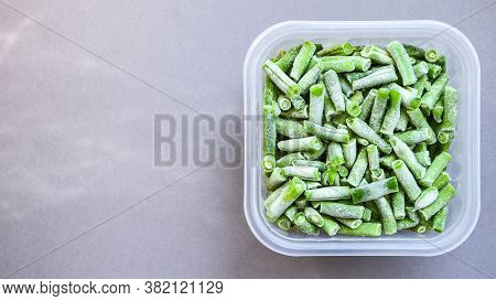 Frozen Green Beans In A Plastic Container For Long-term Storage. Deep Freezing Of Vegetables. Frozen