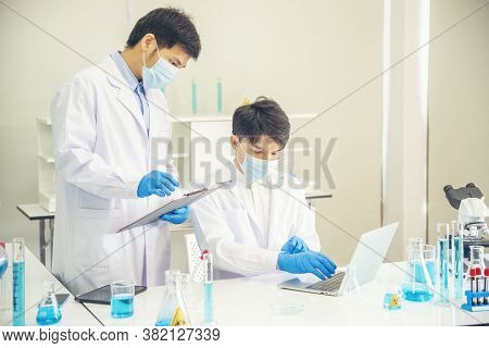 Two Asian Scientist Team Reserch Chemistry Science Tube Experiment Biotech Antibody Sample In Labora