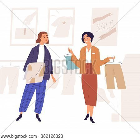 Sales Consultant Demonstrate Clothes On Hanger To Woman Customer Who Choose Clothing In Shopping Mal