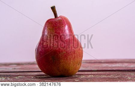 Pear Fruit (pyrus L.) On Wooden Surface On Pink Background