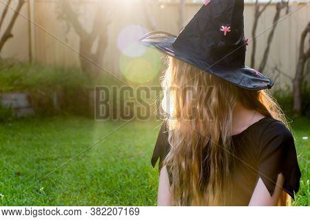 Causcasian Blond Girl With Long Hair In Halloween Witch Costume