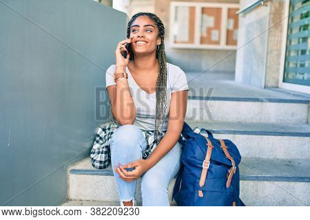 Young african american student woman smiling happy using smartphone at the university campus