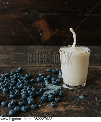 Berries Are Thrown Into The Transparent Glass Making Splashes Of Milk