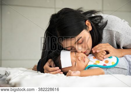 Asian Young Mother Take Care Male Baby Gotten Fever Illness In Bedroom With Copy Space