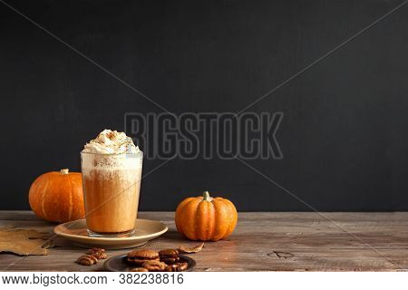 Pumpkin Spice Latte. Seasonal Coffee Drink And Organic Pumpkins Near Black Wall, Copy Space.