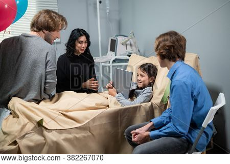 A Girl Talking To A Family Member, Who Couldnt Come To Visit, Over The Internet On Her Tablet, She I