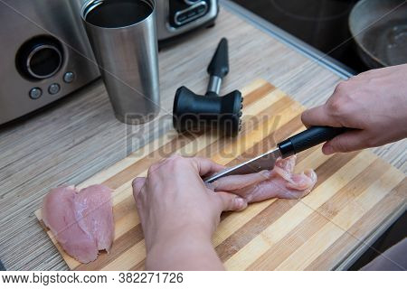 Female Hands Cut Chicken Fillet On Wooden Board With A Knife